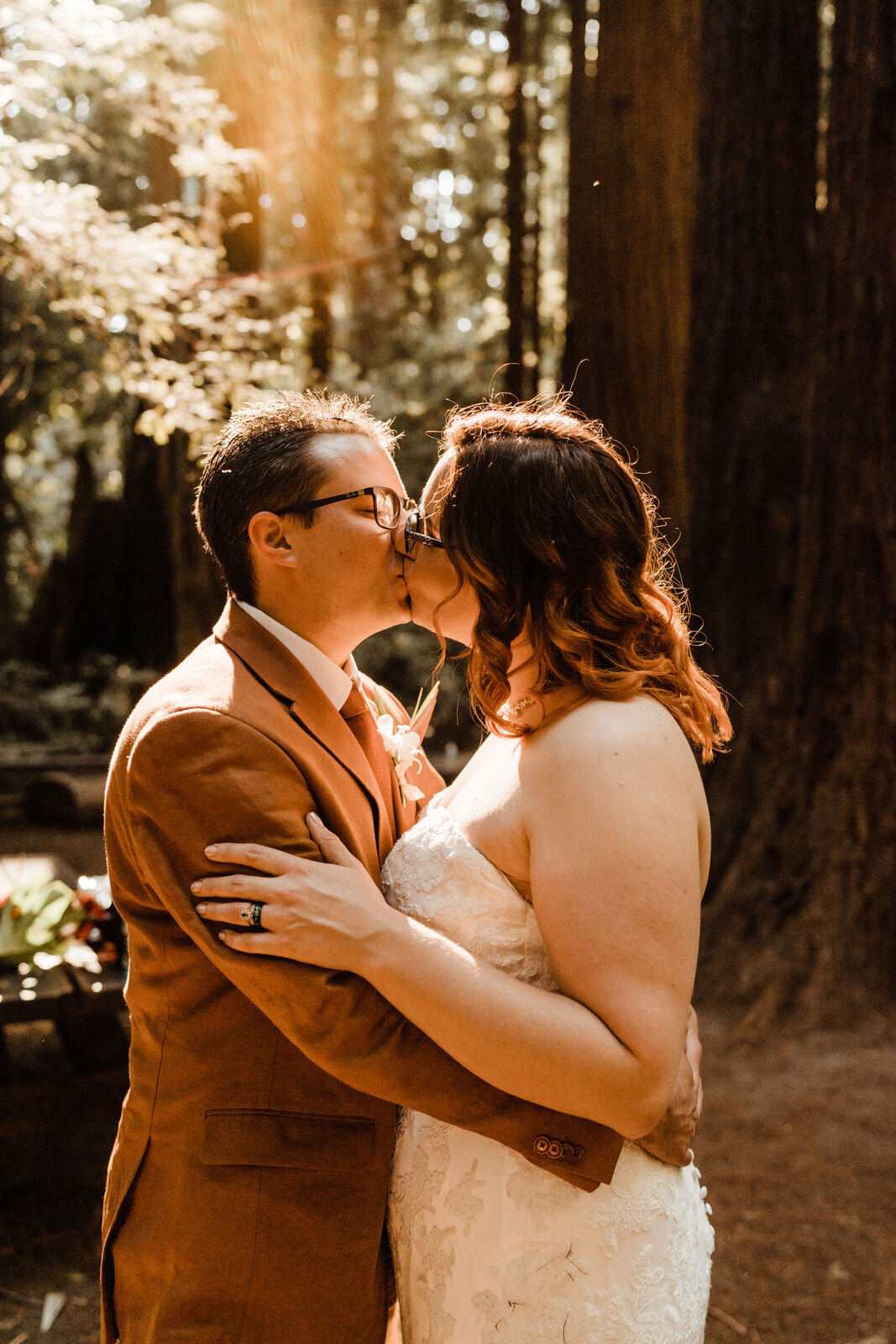 Henry-Cowell-Redwoods-State-Park-Wedding-Santa-Cruz-Groom-in-Rust-Suit-Kissing-Bride.jpg