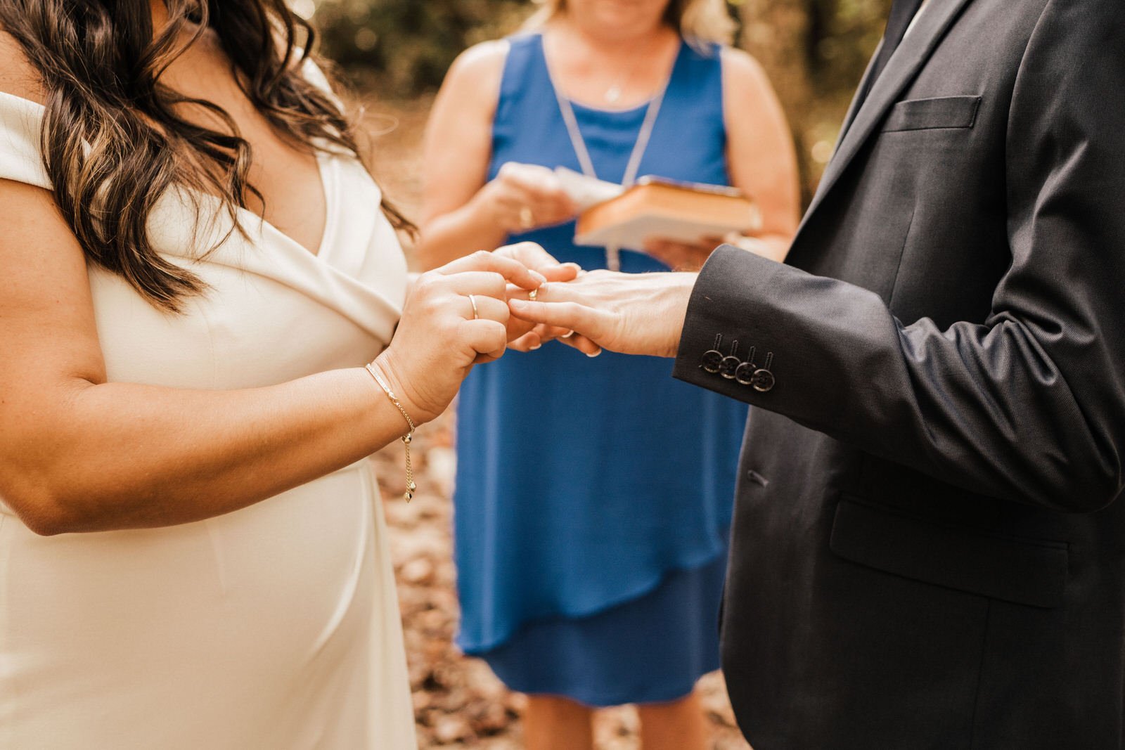 Woodsy-Minimalist-Wedding-in-Roswell-Georgia-Bride-Placing-Ring-on-Finger.jpg