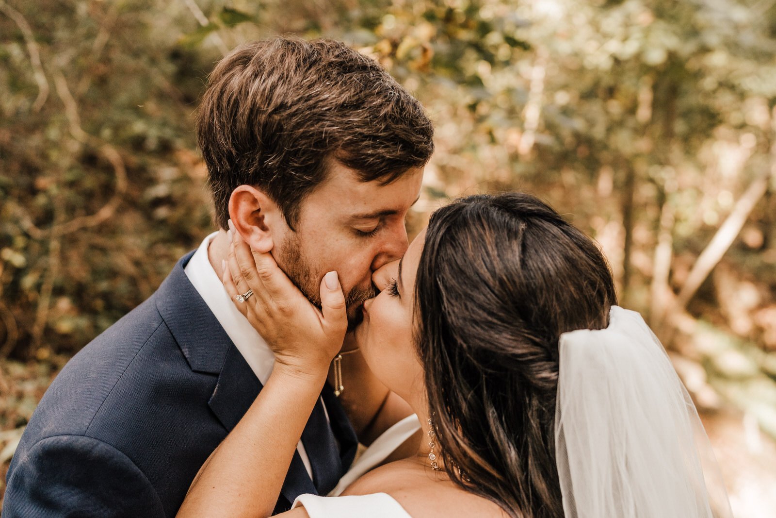 Bride-wearing-off-shoulder-wedding-dress-kissing-Groom-in-Navy-Suit-in-Roswell-GA-Wedding (3).jpg