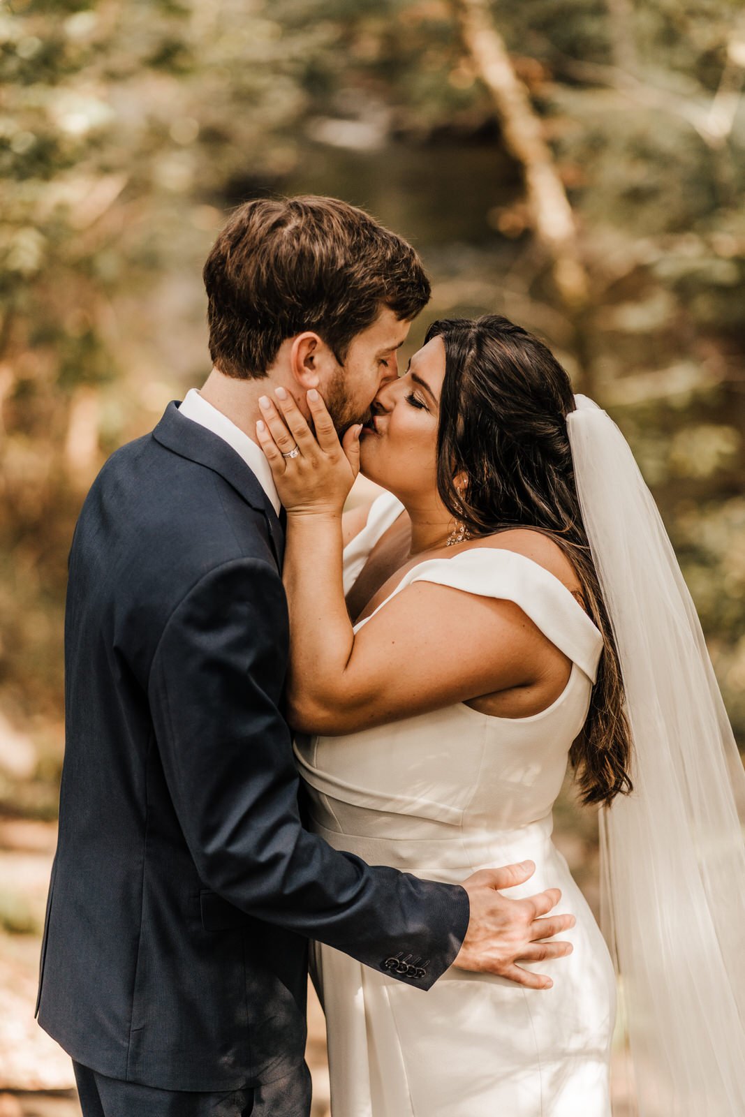 Bride-wearing-off-shoulder-wedding-dress-kissing-Groom-in-Navy-Suit-in-Roswell-GA-Wedding (5).jpg