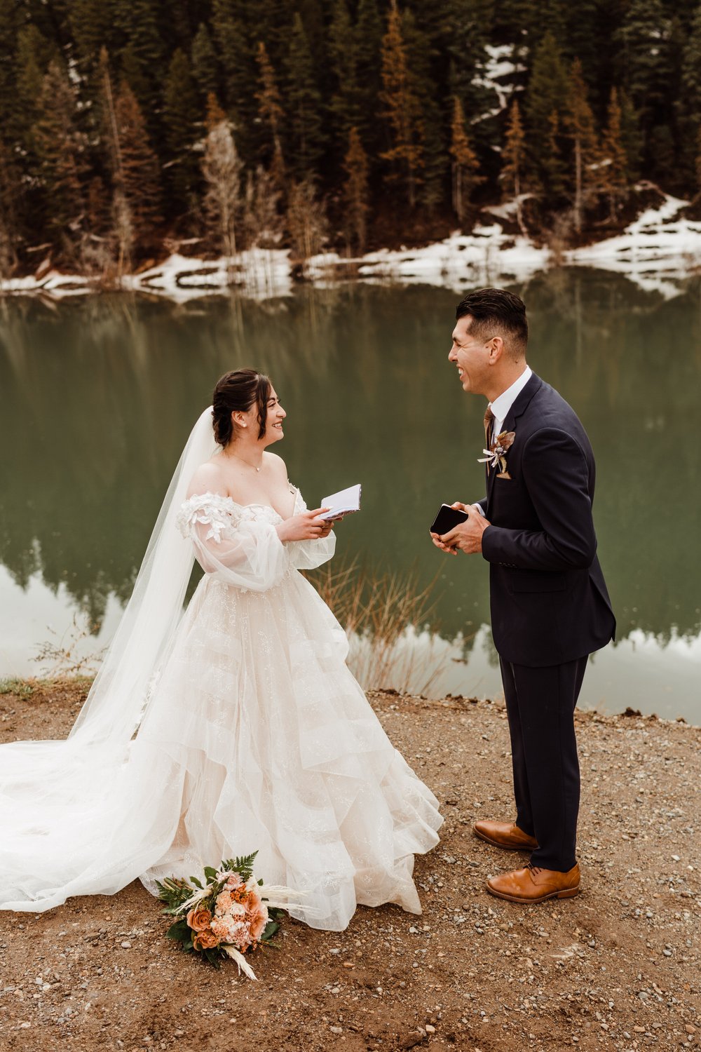 utah-mountain-elopement-bride-reads-vows-by-alpine-lake-couple-laughing.jpg