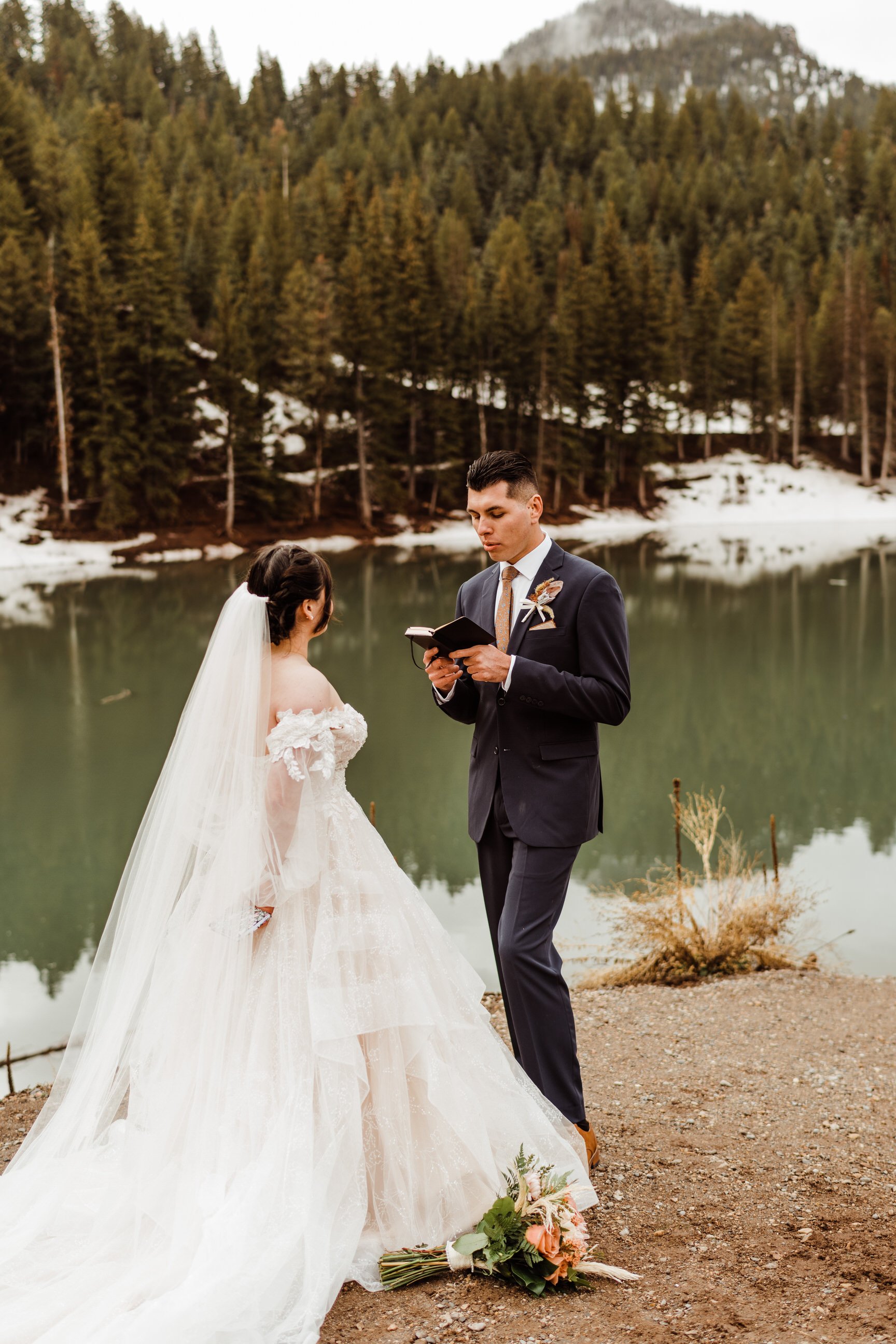 utah-mountain-elopement-groom-reading-vows-by-alpine-lake.jpg
