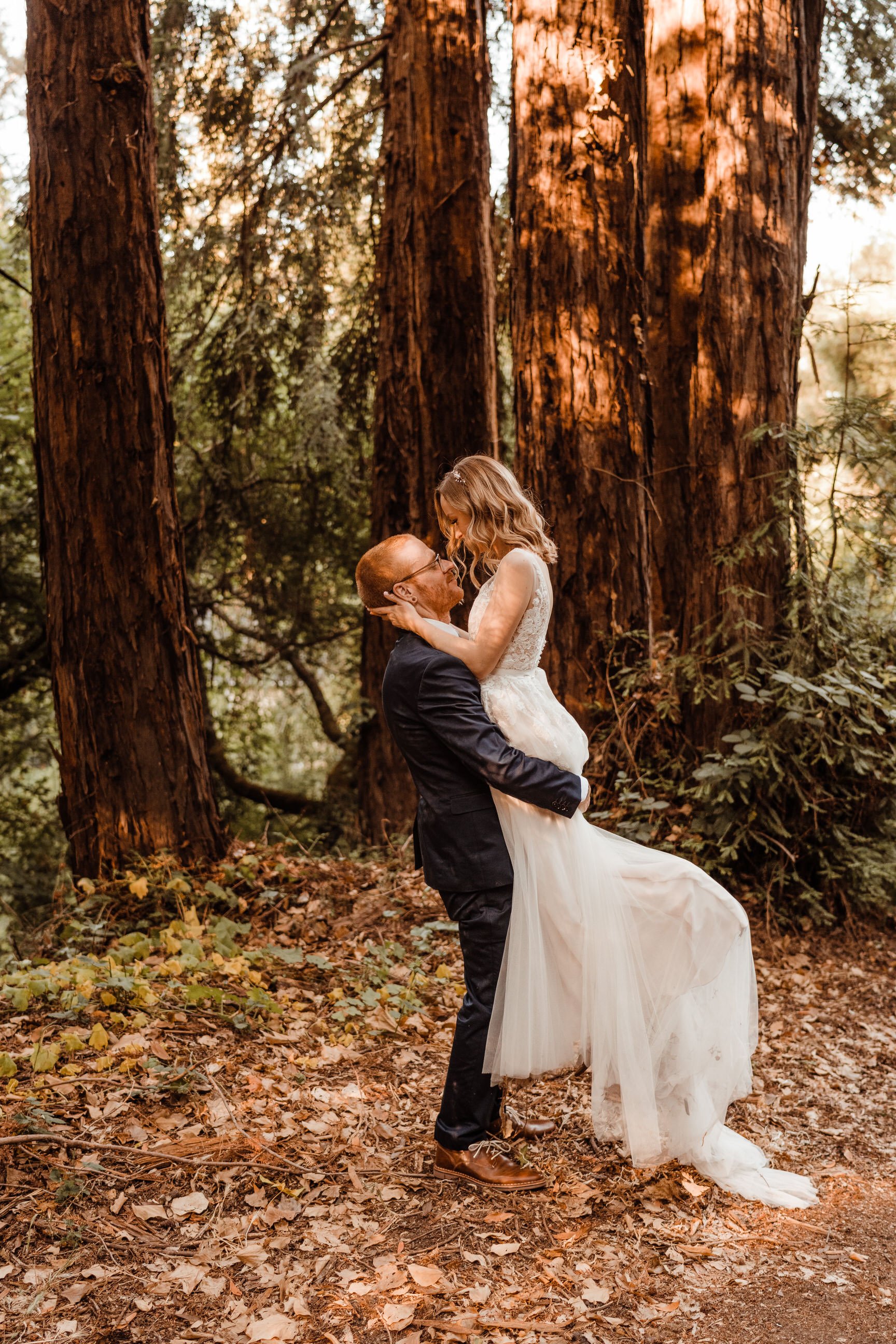 Groom-lifts-Bride-in-Dress-at-Wedding-in-the-Woods.jpg