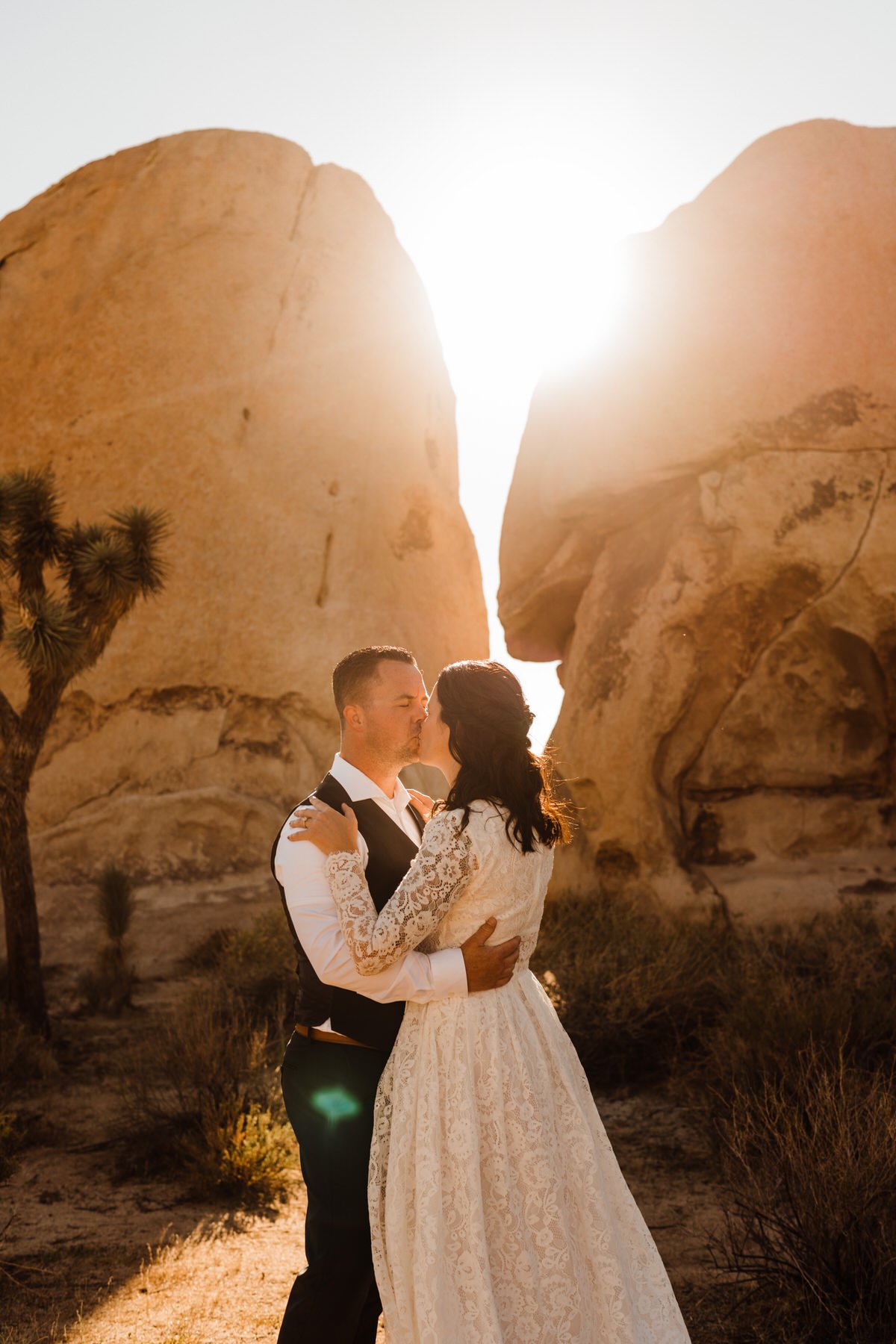 Bride-and-Groom-kiss-In-Front-of-Boulders-at-Joshua-Tree-Golden-Hour.jpg