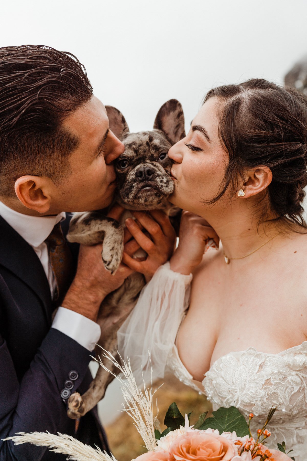 Utah couple kiss French Bulldog Puppy at Mountain Elopement | Dog-Friendly Wedding Photographer + Elopement Expert Kept Record | keptrecord.com
