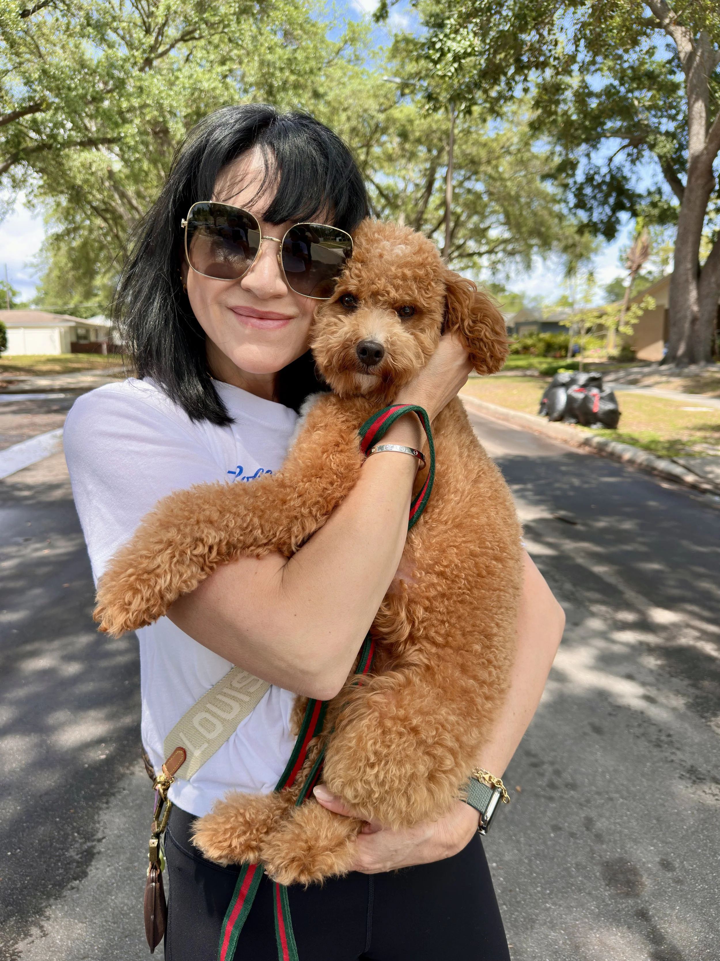 Client holding trained Goldendoodle Leo after completing immersive dog training program with PAWSitively Calm in Orlando, Florida.