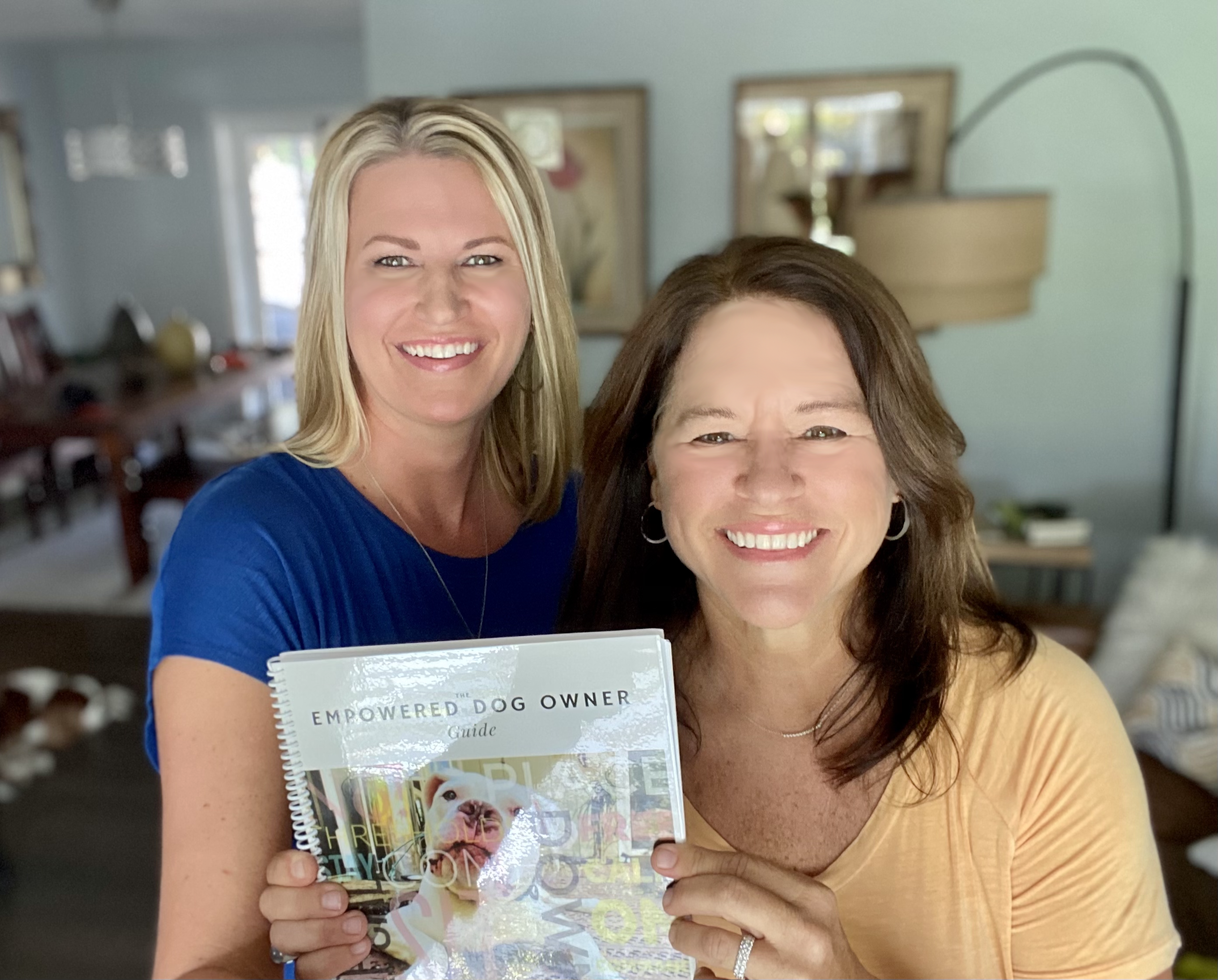 Orlando dog trainers holding the Empowered Dog Owner Guide, representing structured, leadership-based dog training