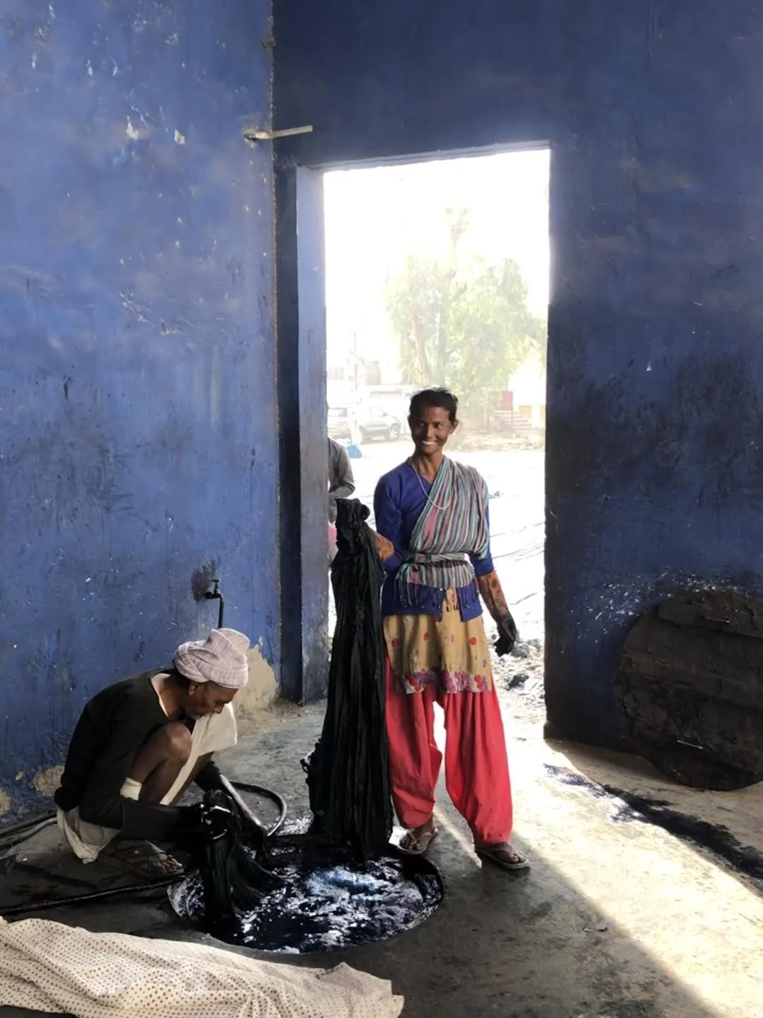 Pulling the dyed fabric out a 12 foot indigo vat to lay it out to dry in the sun and dirt.
