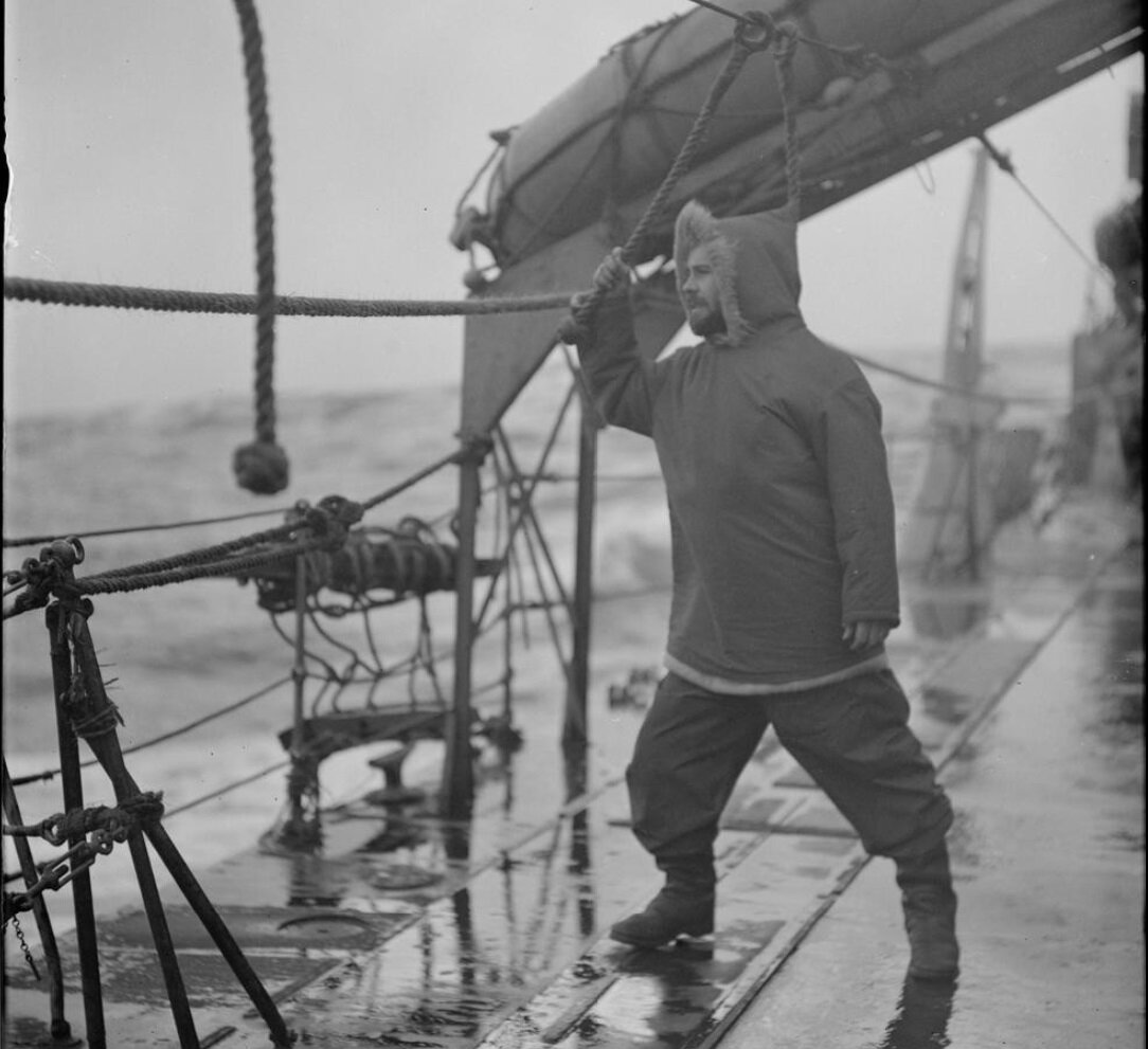 One of the crew of HMS INGLEFIELD holding on to a life line and wearing Arctic dress for Northern patrol duties during an Arctic convoy..jpg