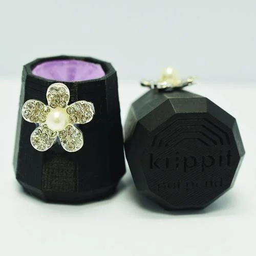 A black and pink Krippit with a jeweled flower.