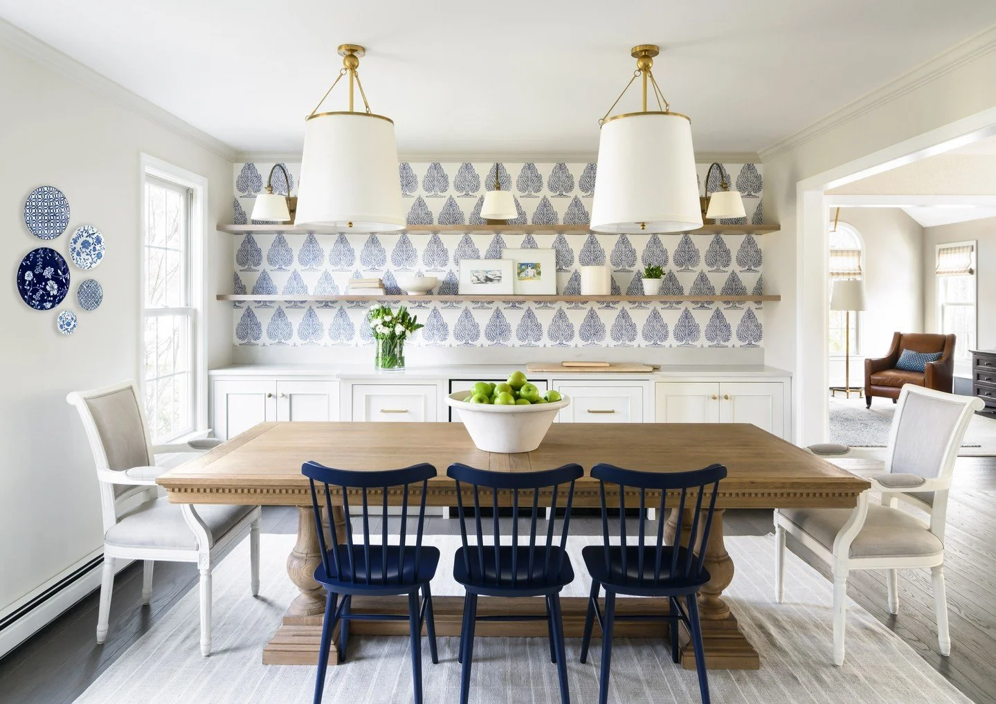 A modern classic in blue and white.
This dining space blends tradition and freshness &mdash; crisp pattern, layered neutrals, and a grounded wood table that invites gathering. The deep navy chairs add contrast and character, while tailored details ke