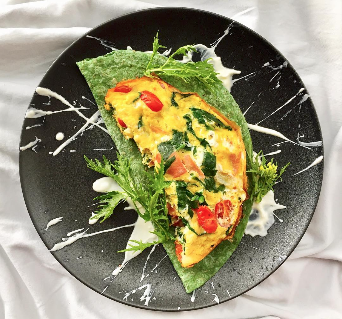 REVOLTILLO ESPAÑOL 🇪🇸 . 🍳 Ingredientes: Pimienta Espinaca 2 huevos Sal rosada Yogurt Griego Goa Jamón serrano Tomaticos uvalina 1 c/dita de aceite de coco Wrap artesanal de espinaca 🍳 Preparación 1️⃣ En un bol bate los huevos 🥚 y añade la espinaca 🍃 cortada en julianas, los tomaticos 🍅 en mitades, el jamón serrano en julianas, sal y pimienta. 2️⃣ En un sartén de teflón a fuego medio pon a derretir el aceite de coco 🥥 añade todo el contenido que integraste en el bol y tapa el sartén. Deja cocinar por 5 minutos. 3️⃣ En otro sartén calienta el wrap. 4️⃣ Decoré con yogurt griego para el toque cremoso y lechugas asiáticas 🌿 ¡Acompáñalo con un delicioso matcha 🍵 latte!