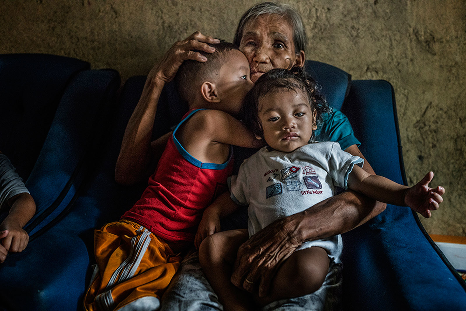  Remy Fernandez, 84 years old, holds her grandchildren that she is raising, there are seven in all, because her son, Constantino de Juan, a methampetamine user, was killed by masked men and the mother is in prison due to a drug arrest. The chair in w