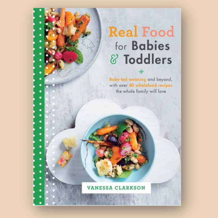 Book cover titled 'Real Food for Babies & Toddlers' featuring a colorful dish of vegetables, carrots, radish, and beans on a cloud-shaped plate.