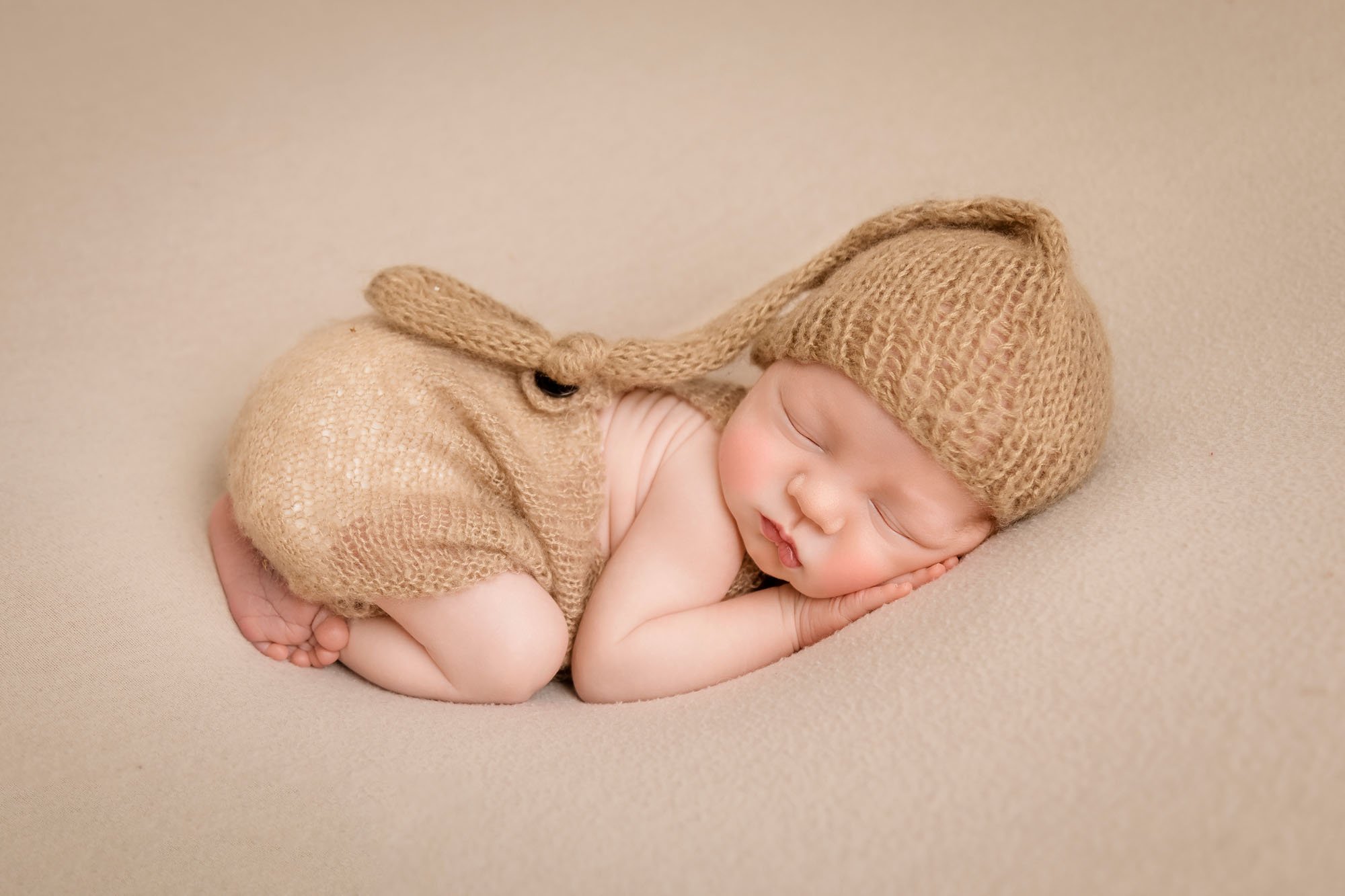 newborn-photography-in-leeds-baby-boy-neutral-cream-bum-up-pose-sleepy-hat.jpg