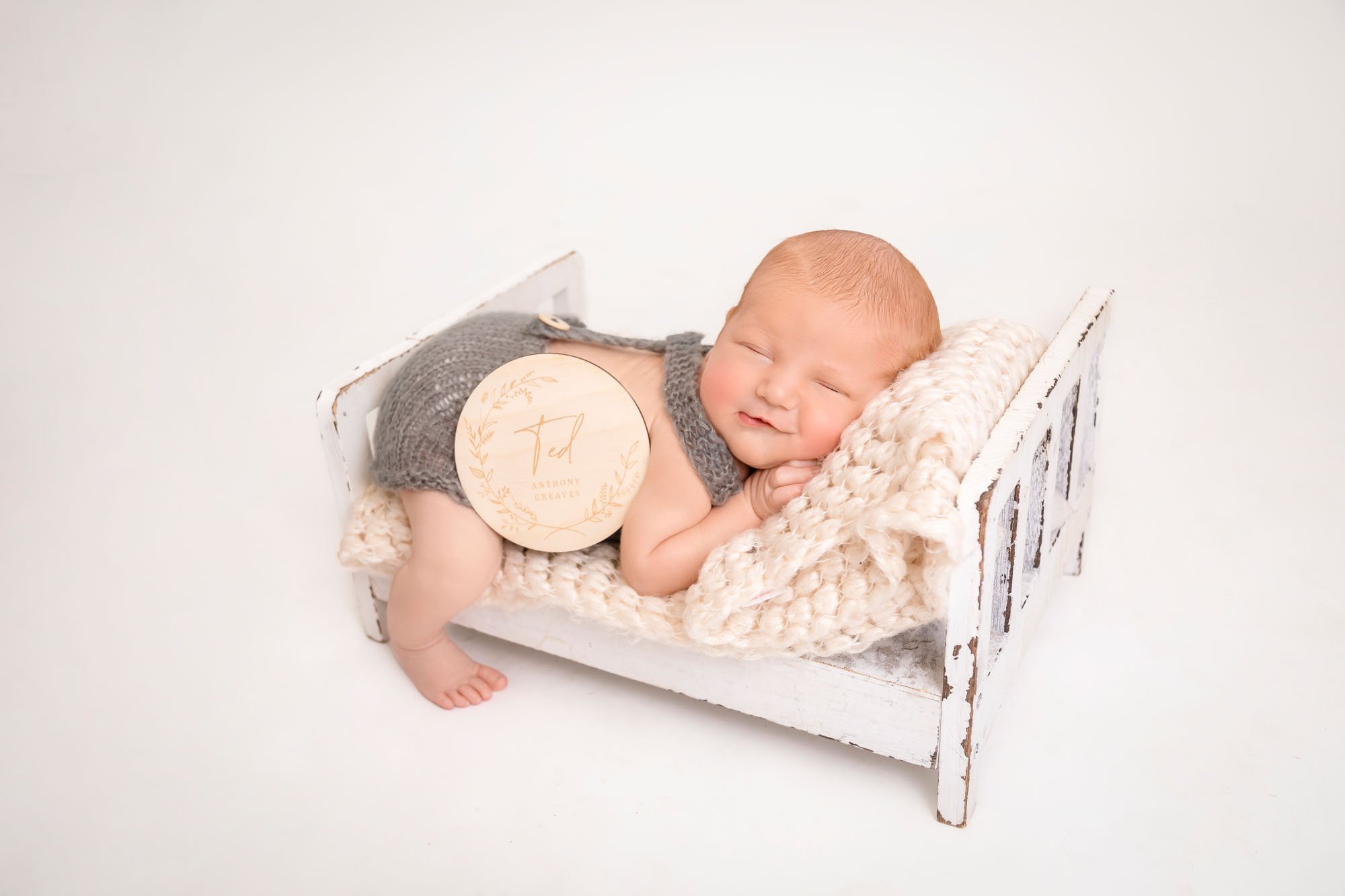 newborn-photography-in-leeds-baby-boy-on-white-bed-name tag.jpg