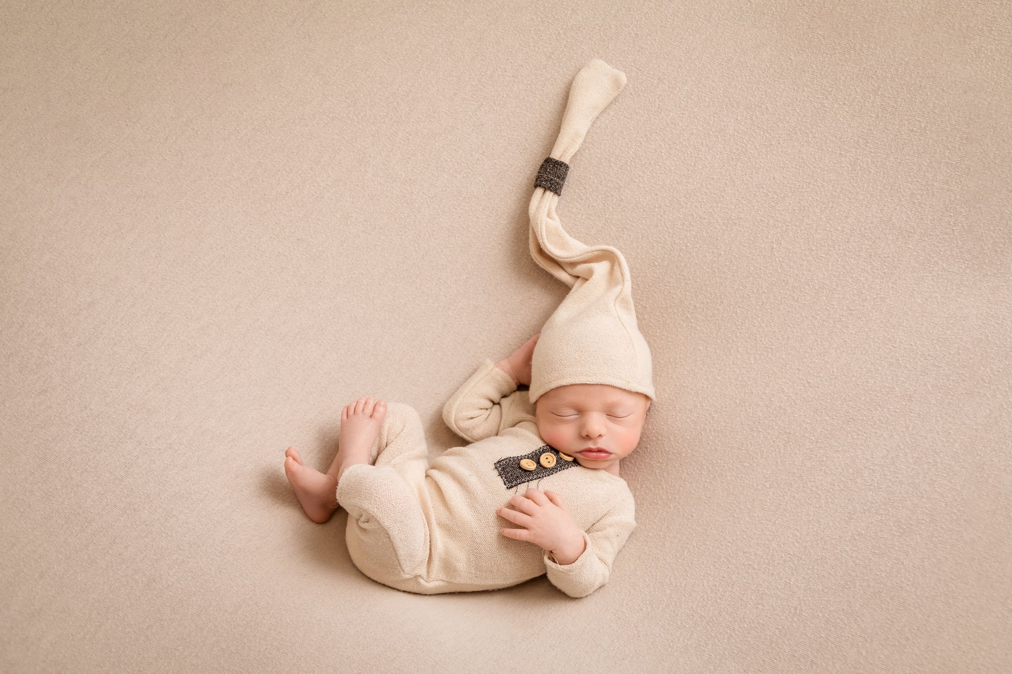 Newborn-photography-in-leeds-boy-in-cream-sleepy-hat.jpg