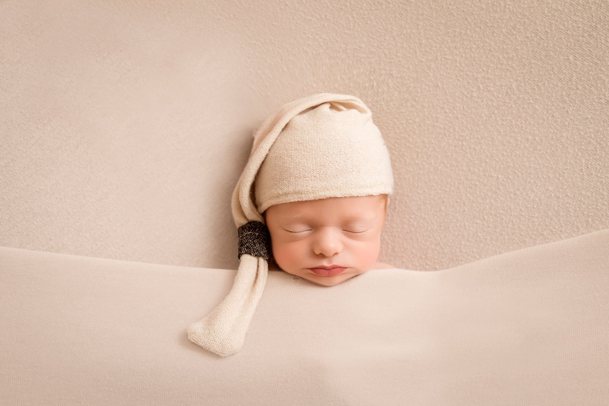 Newborn-photography-in-leeds-tucked-in-bed-cream.jpg