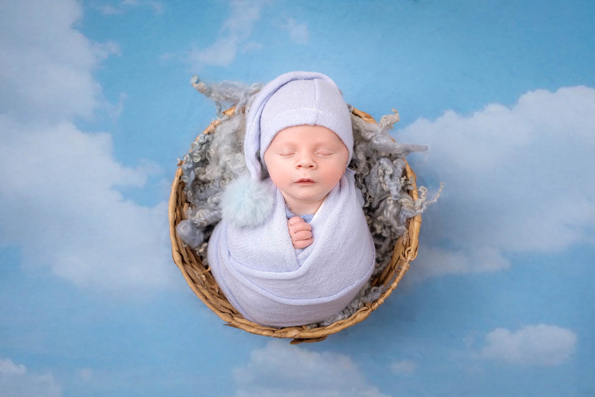 Newborn_photography_in_Leeds_baby_boy_wrapped_in_basket_clouds.jpg