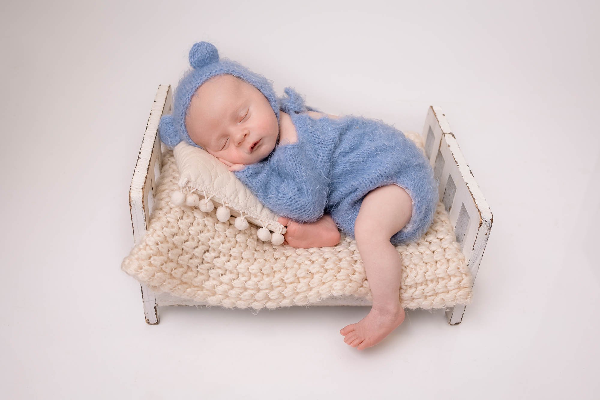 Newborn_photography_in_Leeds_baby_boy_sleeping_on_bed.jpg