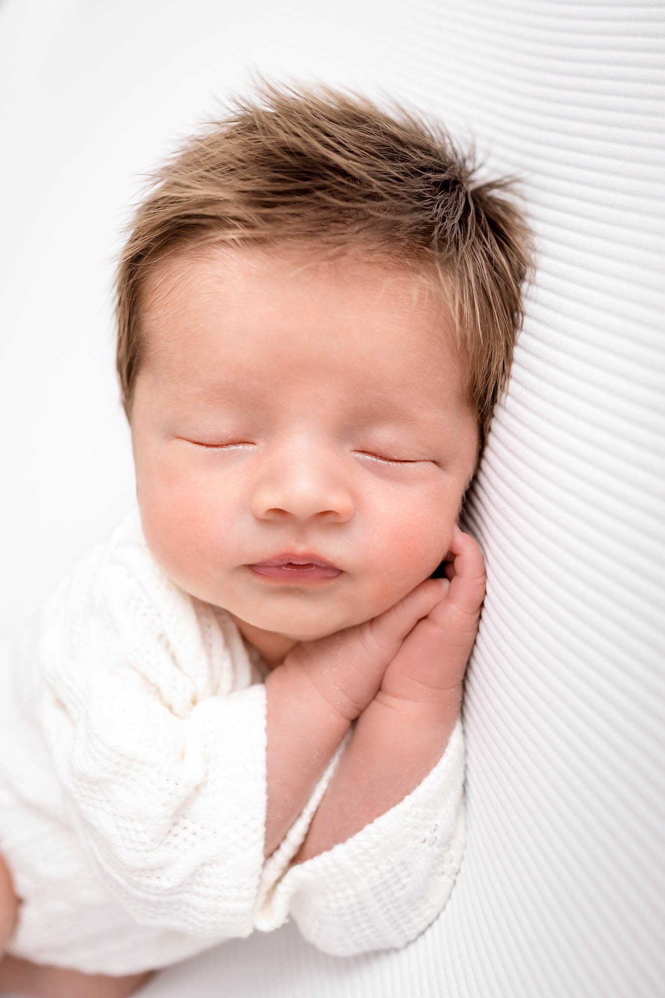Newborn_photography_in_Leeds_baby_boy_on_white_sleeping_hair.jpg