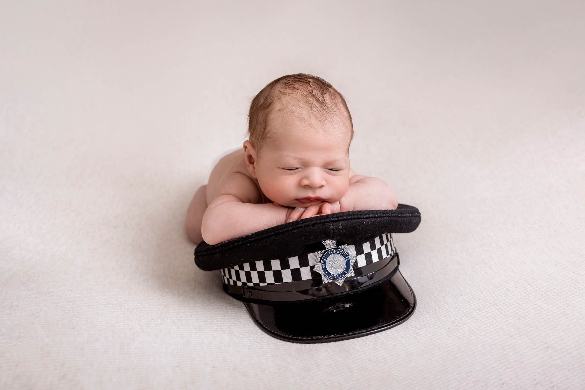 Newborn_photography_in_Leeds_baby_boy_on_police_cap.jpg