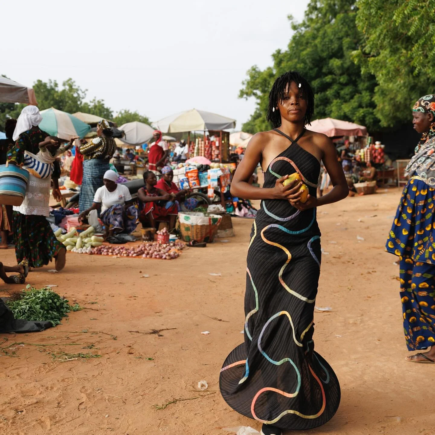 @nbadoit shopping for mangos at th&eacute; Bolomakot&eacute; garden market.
Photo by @misperlens 
Dress : &ldquo;winding path&rdquo; available on the website made to measure

#africanmadefashion #biascutdress #marketdress #handwovenfashion #madetomea