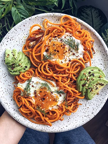 Spiralized sweet potato egg nests with avocado, dill and chili flakes.