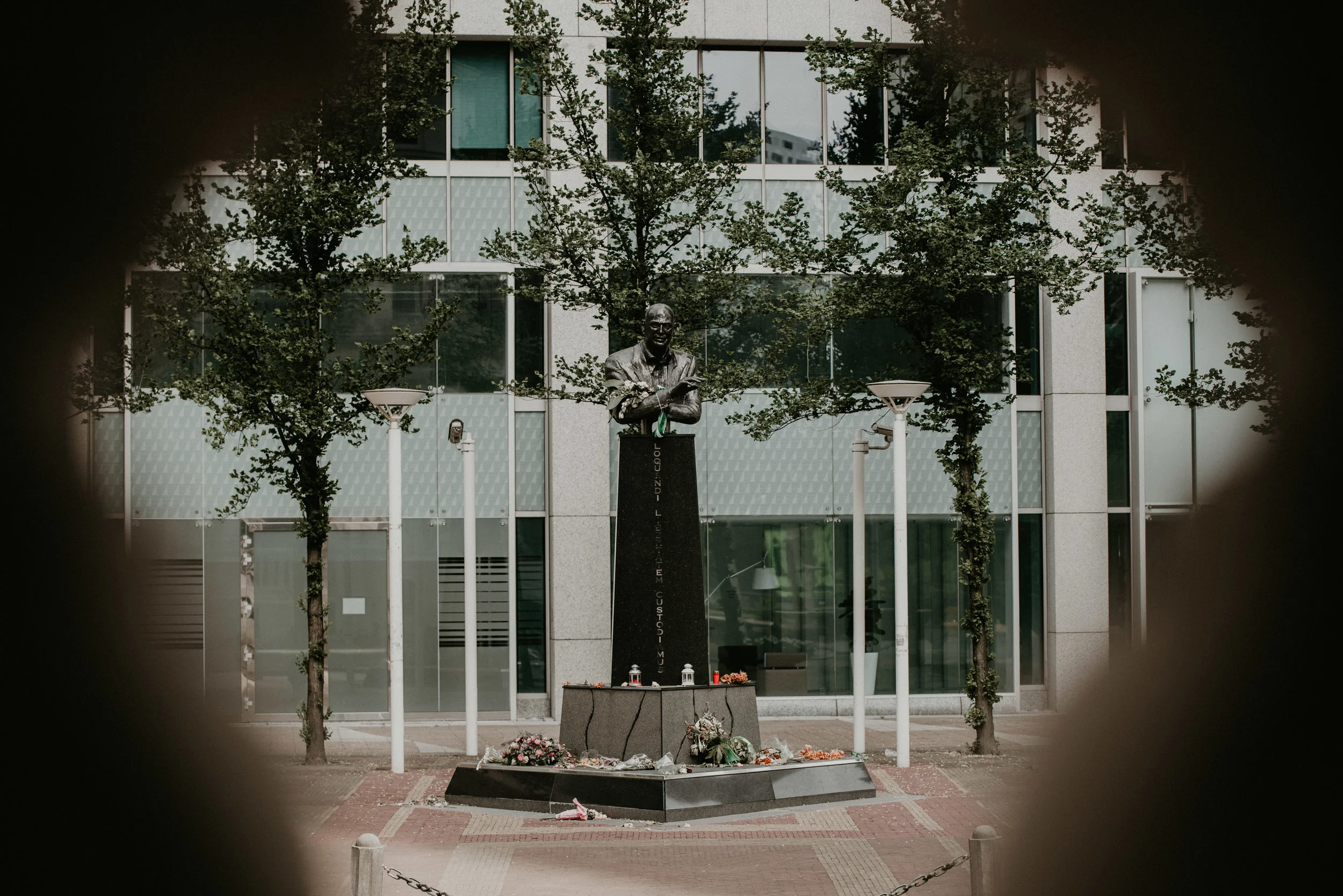 Statue of Pim Fortuyn in Rotterdam Center with flowers all around.