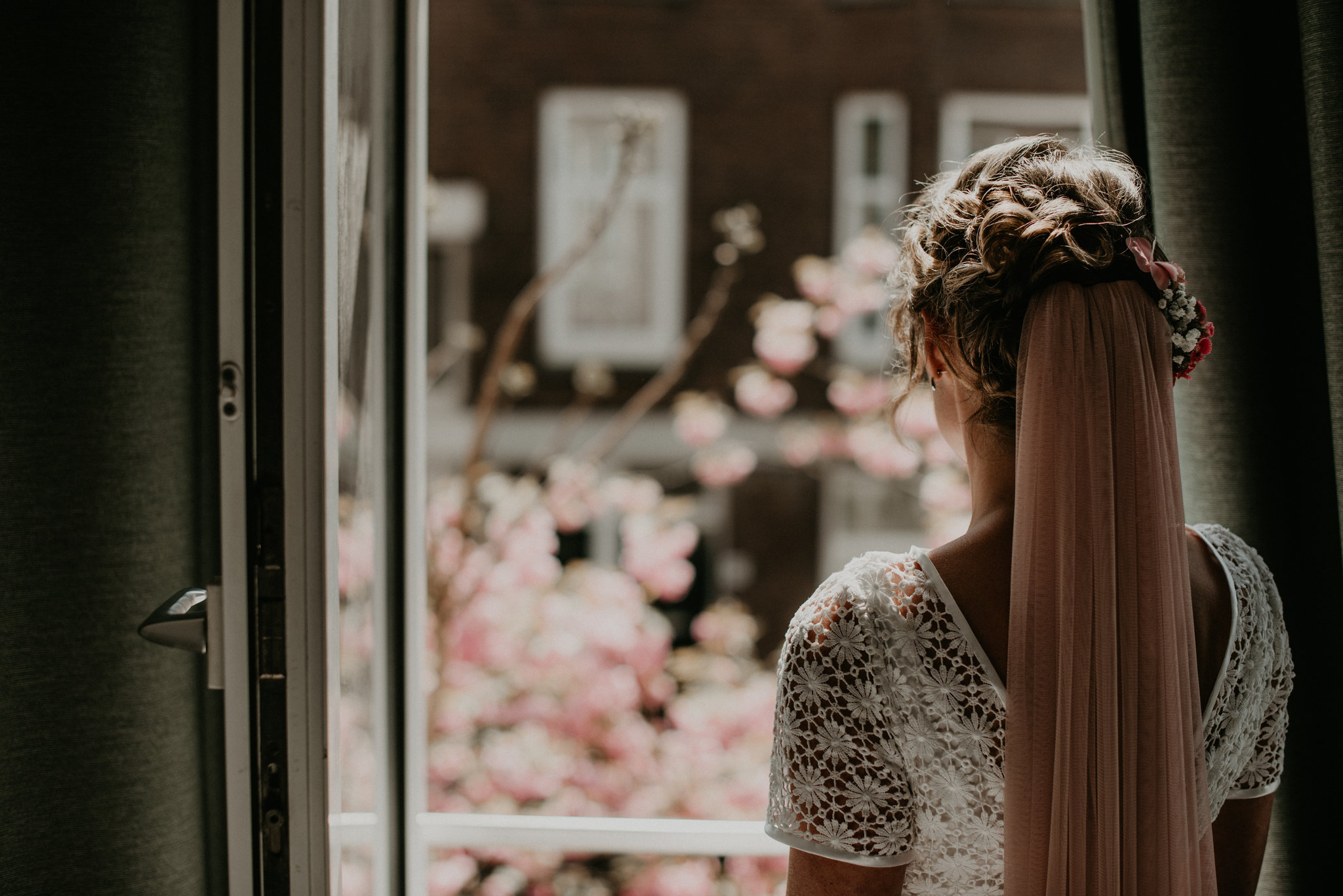 Rotterdam bride looking our her bedroom window looking for her groom