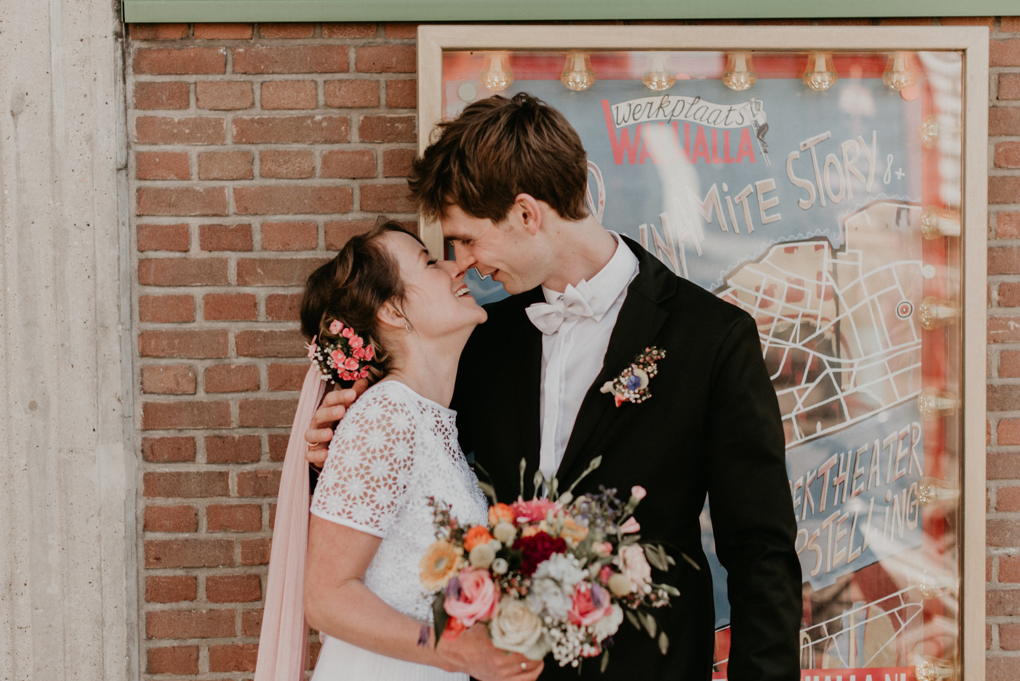 bride and groom standing in froming of a movie poster at de Walhalla in rotterdam Nederlan