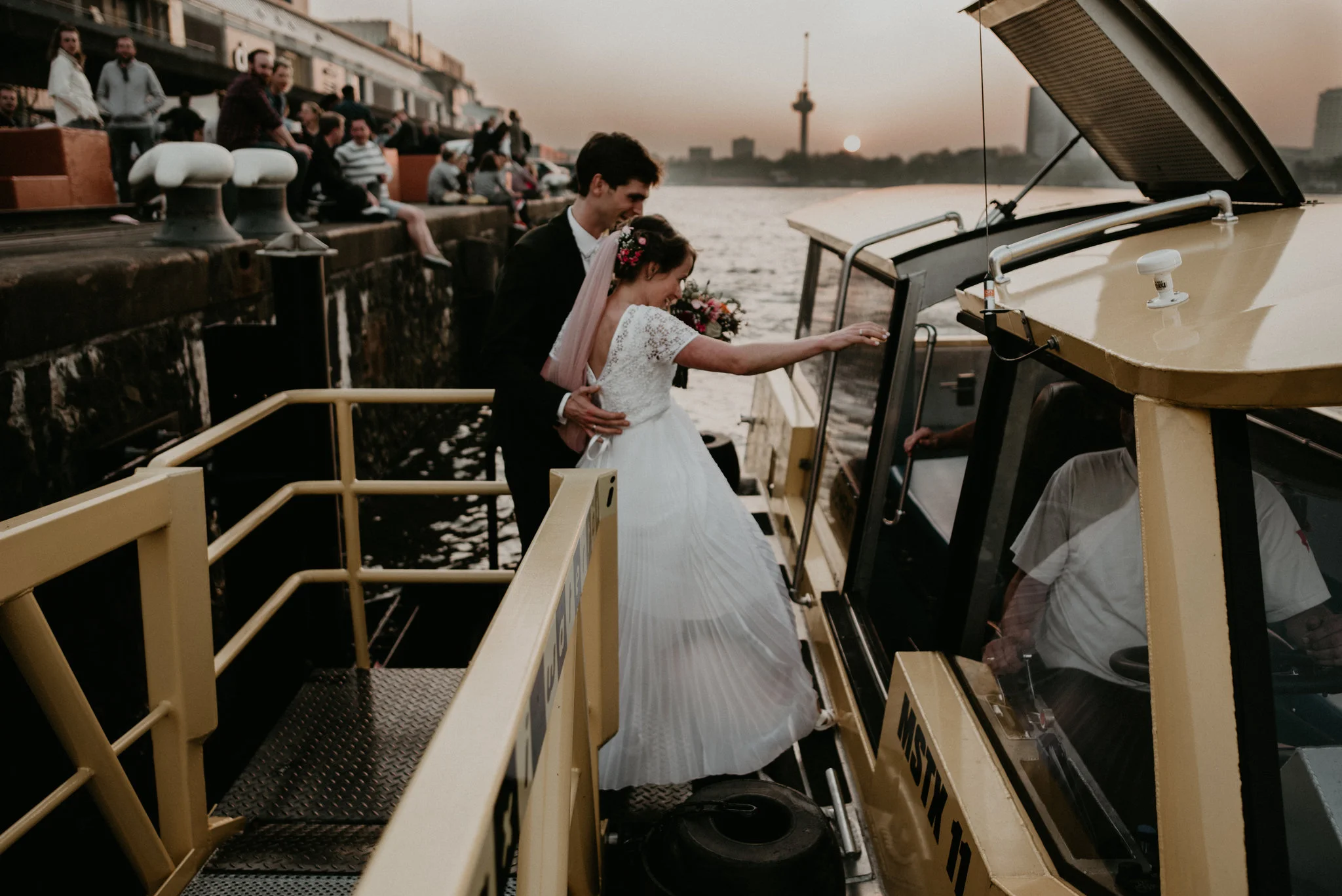 bride and groom getting into the rotterdam water taxi at sunset