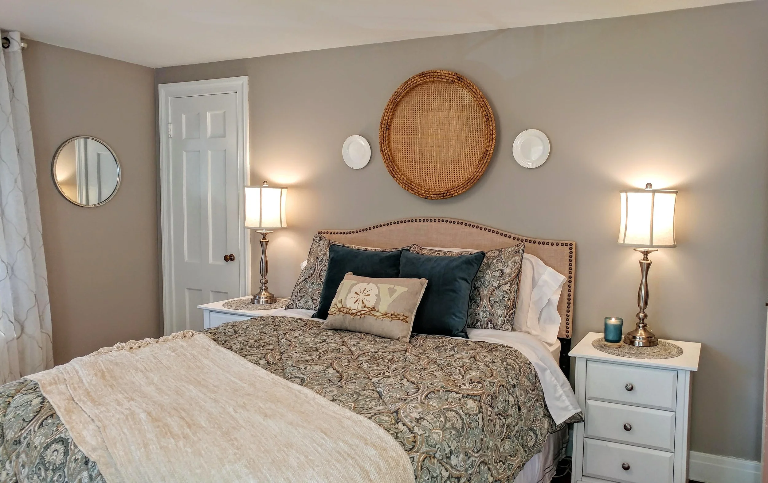 BLOOM: Natural, contemporary wall decor as well as new throw pillows, a cozy blanket and new bedside lamps enliven this corner of the bedroom.