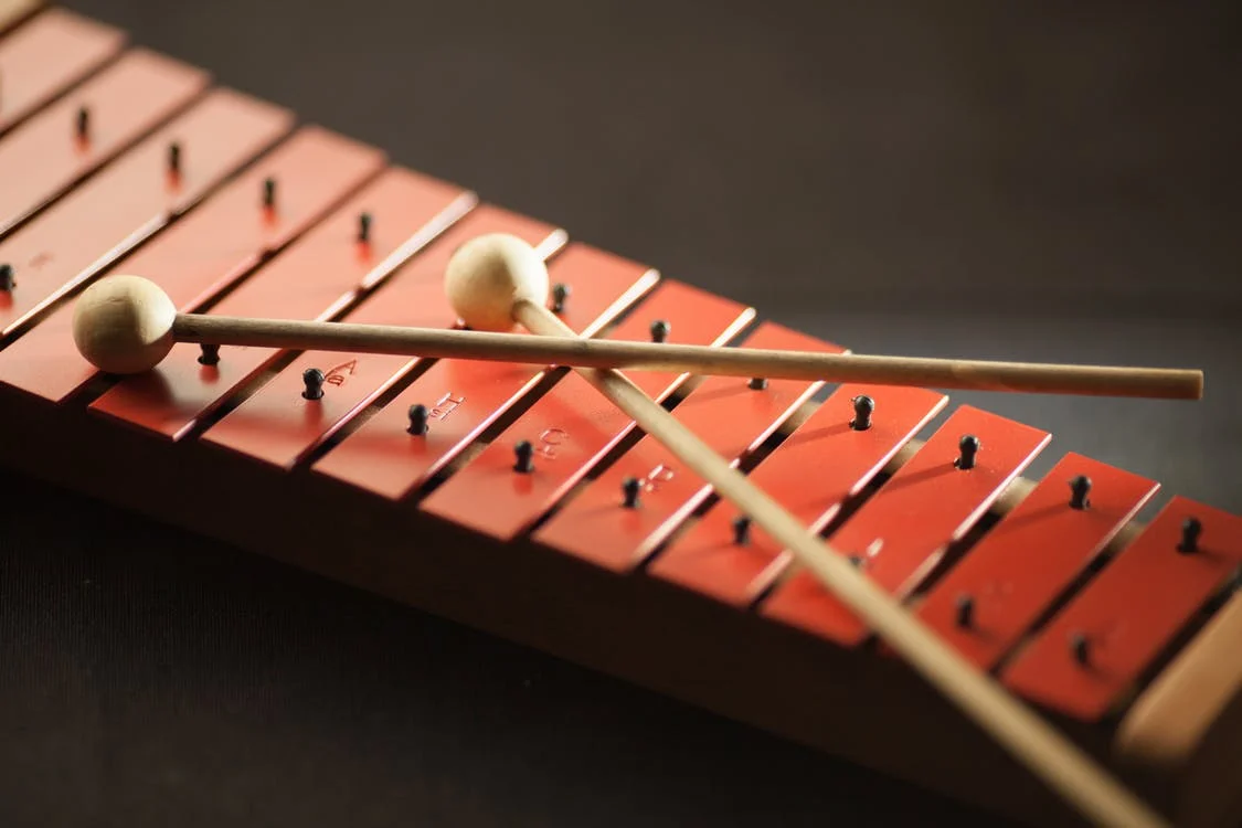 Red xylophone with two sticks on top