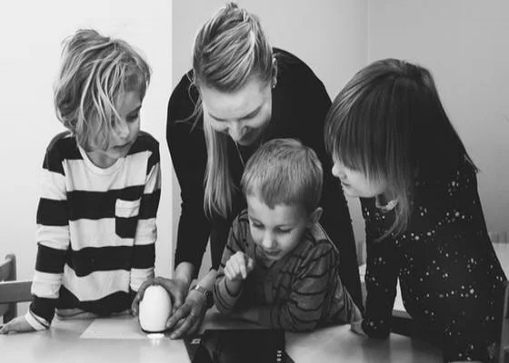 Teacher with three students looking at a tablet