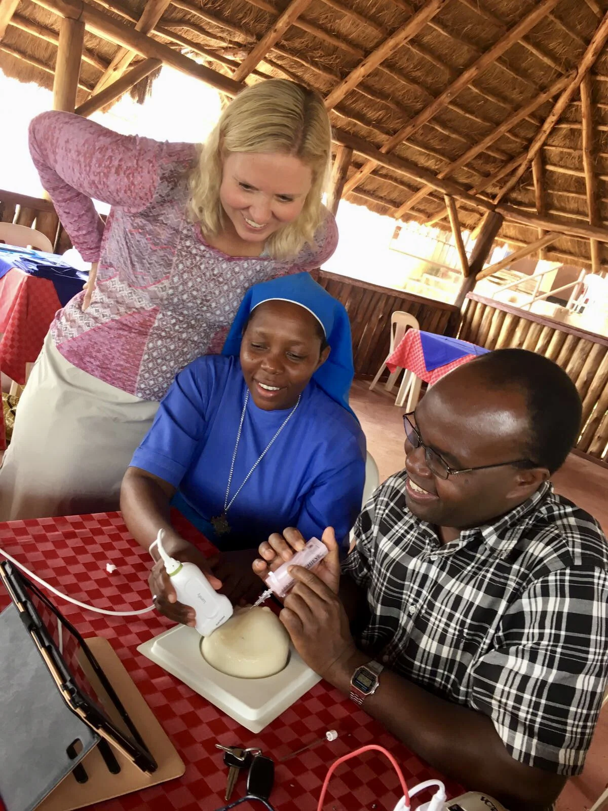 Dr. DeStigter, Sister Angela, and Dr. Alphons practicing with some new portable ultrasound units for breast biopsies along the banks of the Nile River.