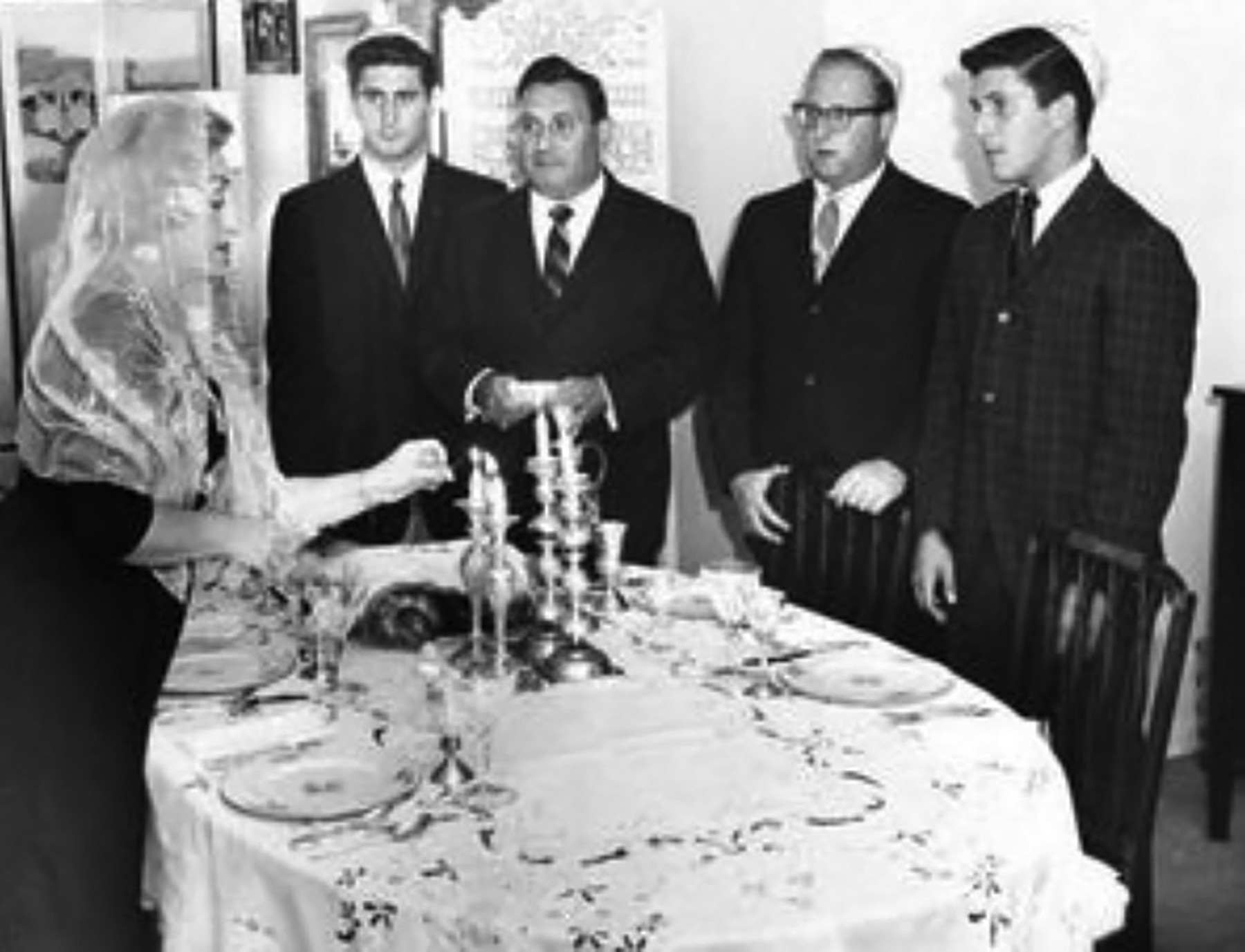  My mother lighting the candles on the Shabbos Eve in our home in Great Neck, Long Island, with ( left to right ) me, my father, and my brothers Barry and Henry.  (From the personal collection of David N. Tucker) 