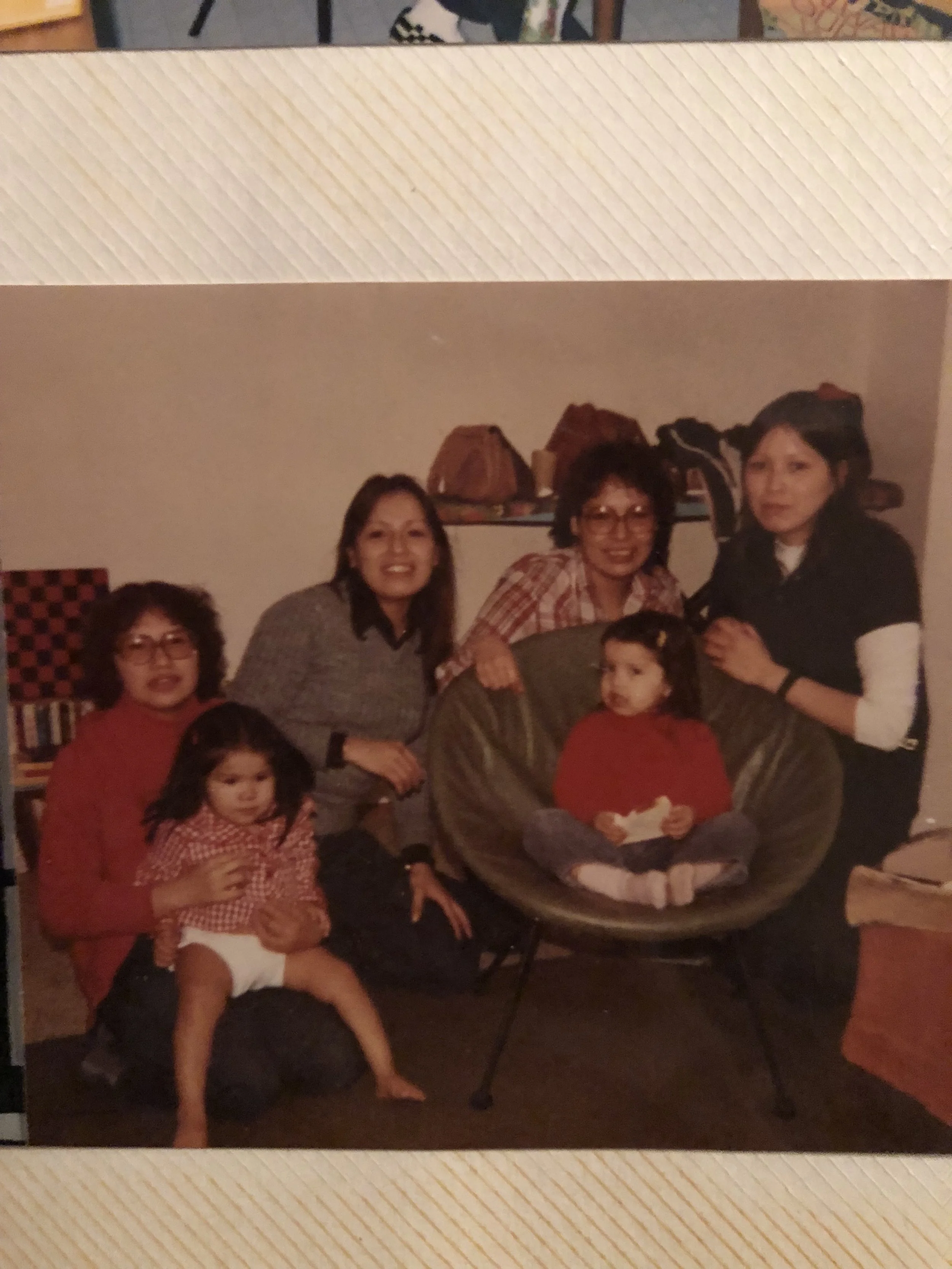 My mother on the far right with my two aunts to her right, their cousin, my second cousin and me in the green chair.