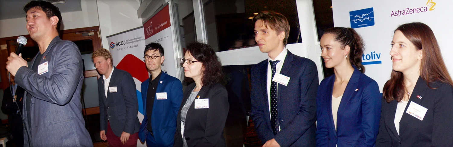 Representatives of the CLIC Chambers introduce themselves; on stage Leon Esben Ota (DCCJ), behind from left: Marin Koos (SCCJ), Arnold Ackerer (ABC), Sophie Bocklandt (BLCCJ), Jorg van Leeuwen (NeCCJ), Anette Yamamoto-Hansen (NCCJ) and Lilo Schneider (SCCIJ). The last, Clas Bystedt (FCCJ) behind the camera.