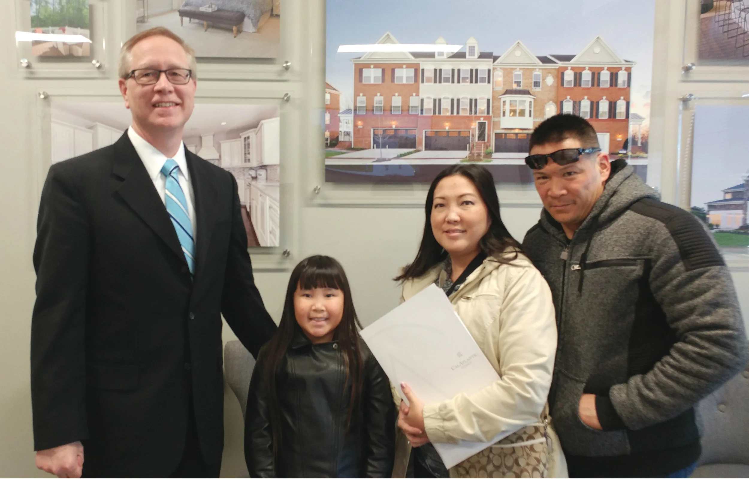 Jerry Kline (left), Realtor with Keller Williams Flagship of Maryland, celebrates with Travis, Leslie and Jenna on the purchase of their new-construction home in the greater Fort Meade, Maryland, community of Glen Burnie. The family just relocated from Hawaii, and moved into their new home just in time for Jenna to see her first snowfall!