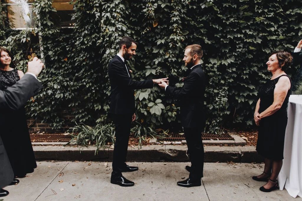 Exchanging of the rings, same-sex outdoor wedding ceremony in Linden Hills Minnesota
