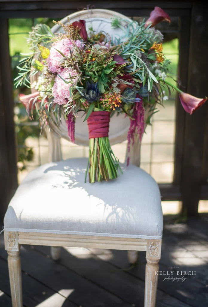 Bohemian inspired bouquet in pinks, blue, orange with wildflower accents