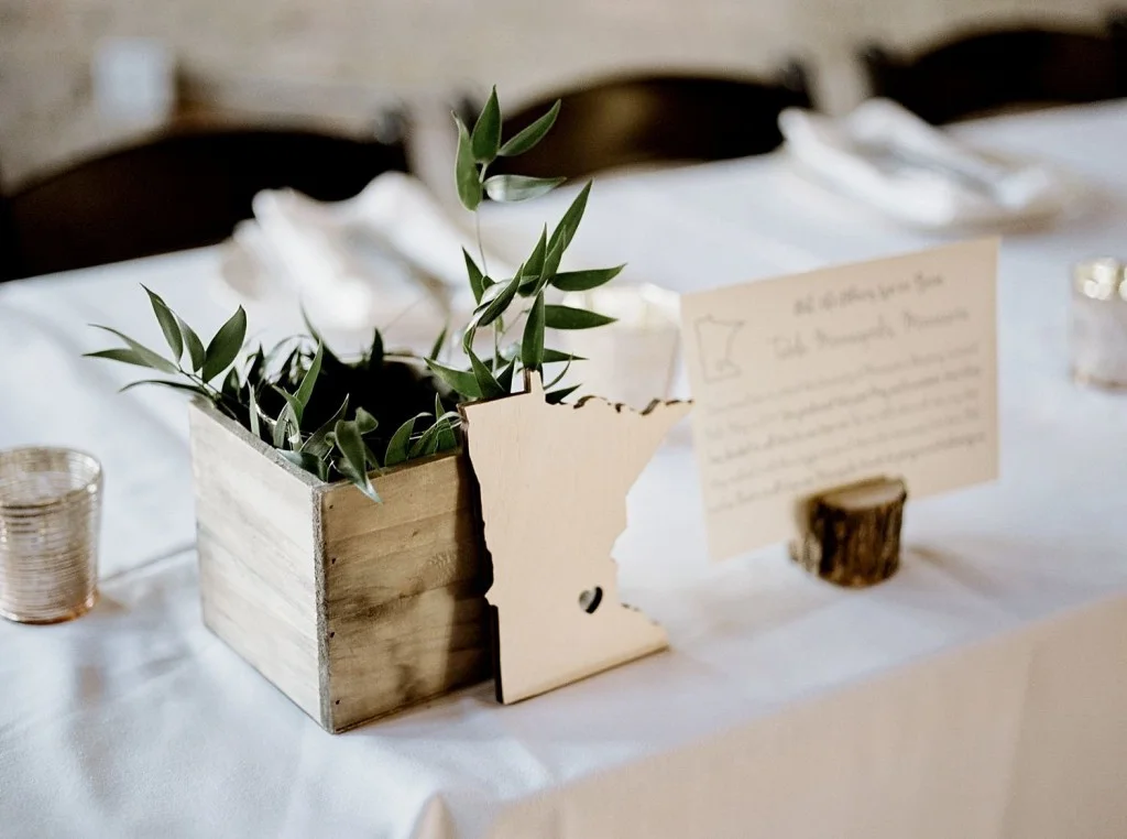 Table number and minimal centerpice with greenery and rustic tones
