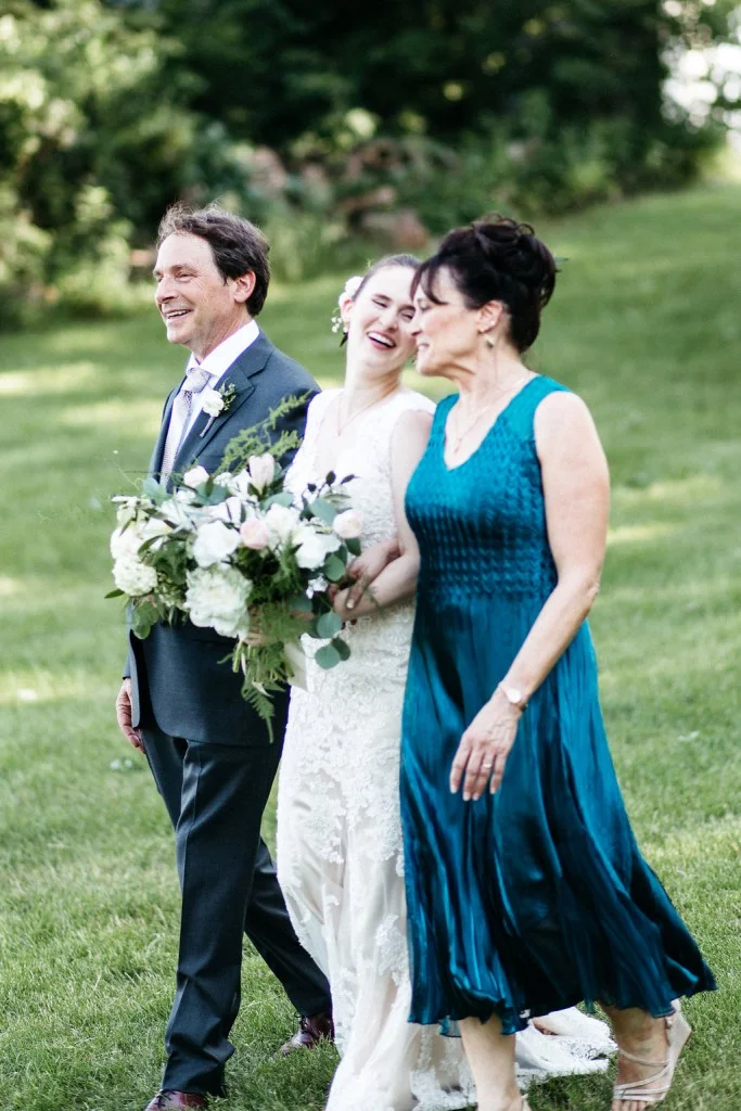 bride walking down the aisle with parents for outdoor wedding at Red Barn Farm