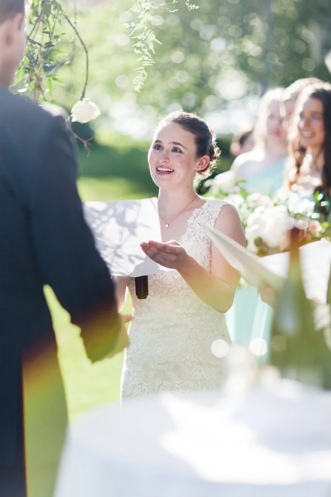 Bride reading vows during outdoor wedding ceremony at red barn farm