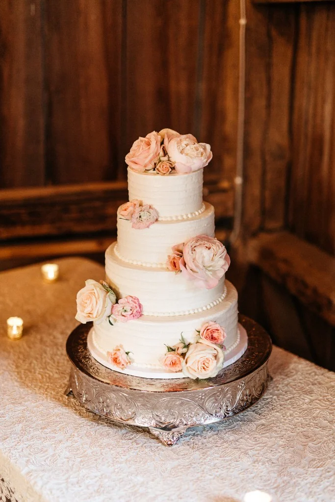 four tier white wedding cake with fresh blush florals