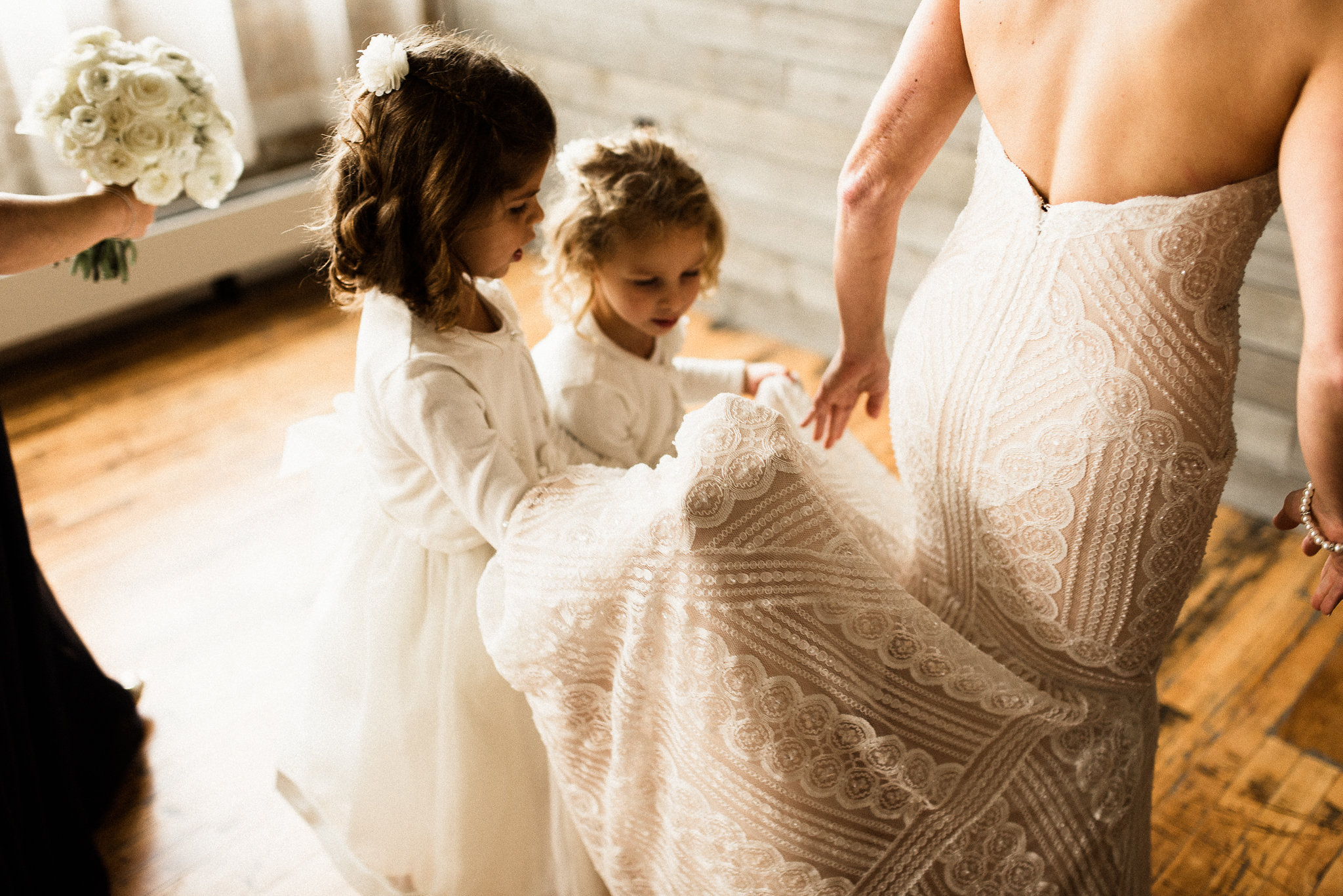 flower girls helping the bride with her dress