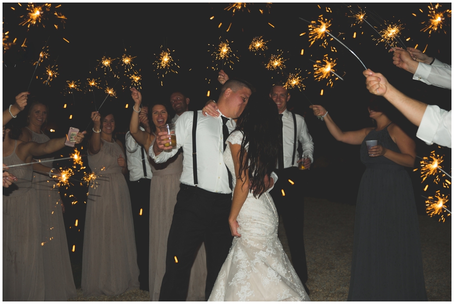  bride and groom surrounded by sparklers at their wedding 