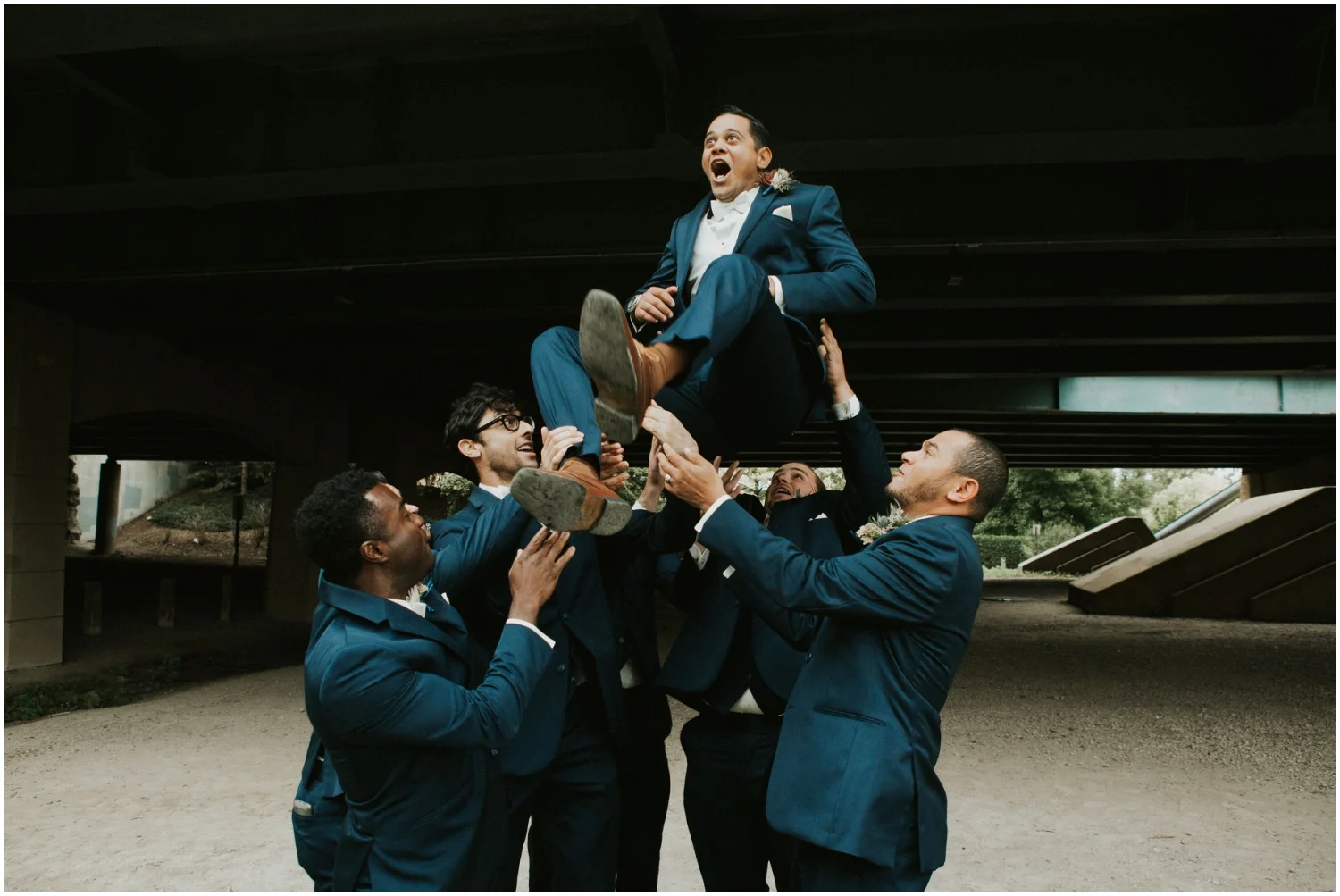 Groomsmen carrying the Groom up in the air