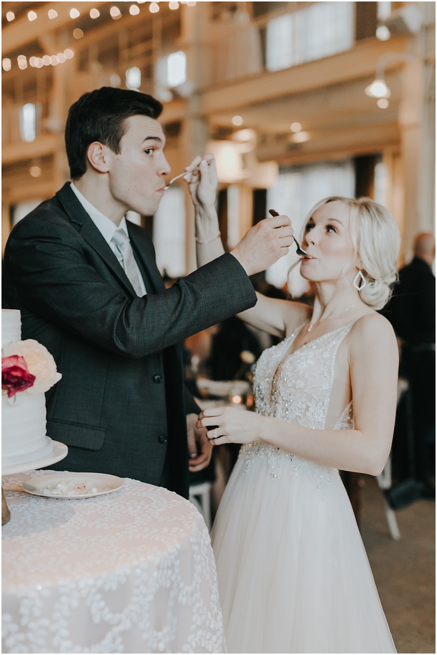  bride and groom being silly while they eat their wedding cake 